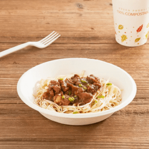 Biodegradable bagasse salad bowl made from sugarcane fibers, filled with healthy salad, sustainable food packaging option