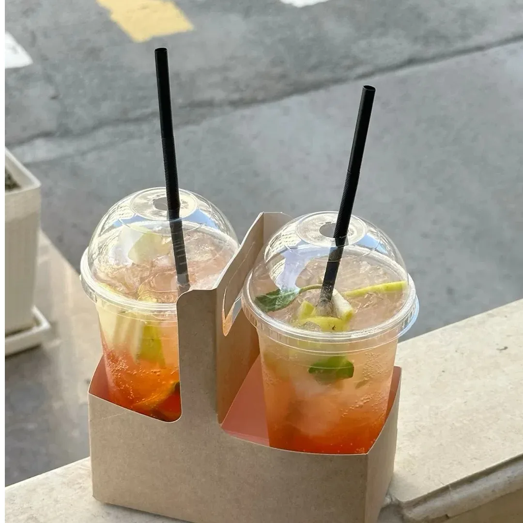 Tazze fredde in PLA compostabili per succhi di frutta, frullati e bevande ghiacciate sul tavolo del bar.