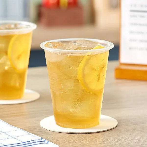La cadena de bebidas adopta vasos de PLA compostables para un servicio sostenible Vaso transparente de PLA compostable lleno de té helado de limón sobre la mesa de una cafetería, en representación de una cadena de bebidas que cambia los vasos de plástico por vasos biodegradables en aras de la sostenibilidad.