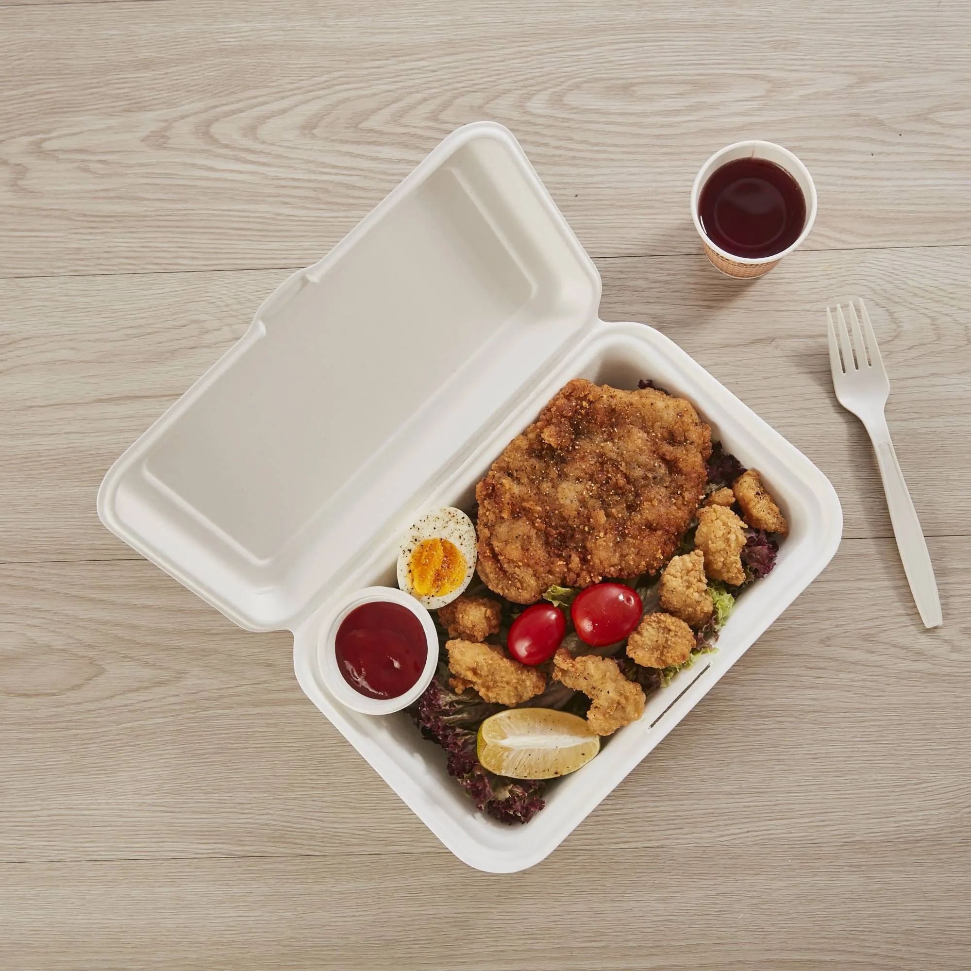 Bagasse Clamshell for High-Heat and High-Oil Meals Biodegradable bagasse clamshell container designed for high-heat and high-oil meals, shown with a fried chicken meal and sides.