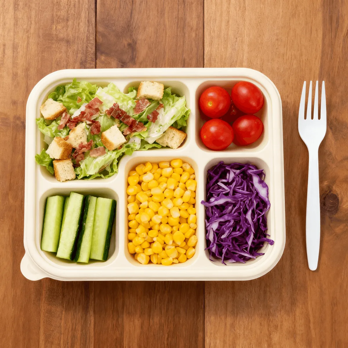 Cornstarch biodegradable food container filled with salad, vegetables, and cold ingredients, showing its suitability for GCC-approved compostable packaging and industrial composting.