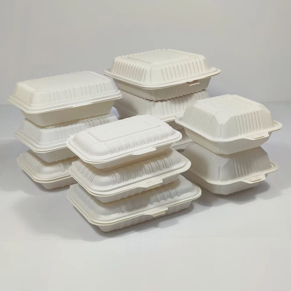 Biodegradable cornstarch clamshell containers stacked in multiple sizes, suitable for medium-heat and medium-oil takeaway meals.
