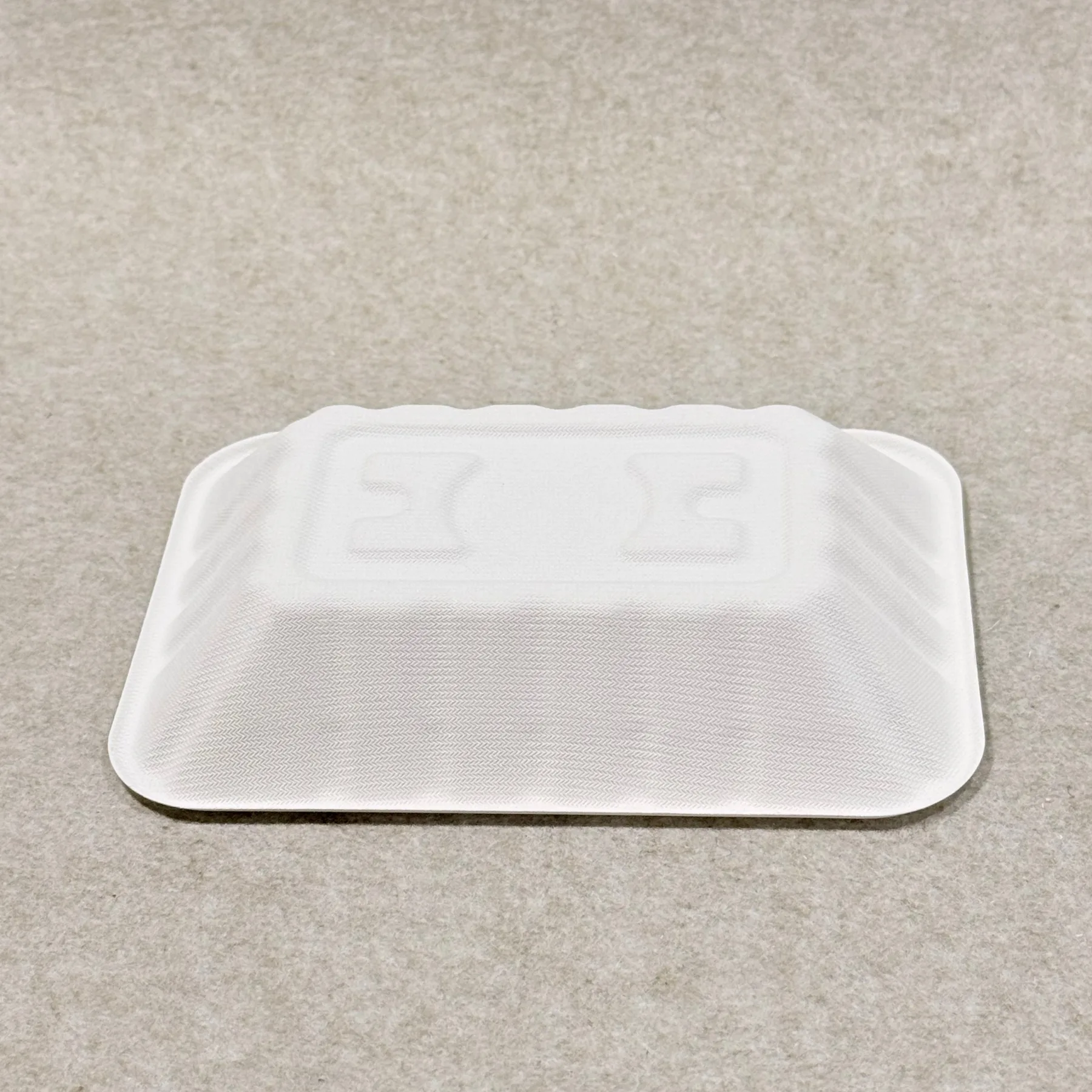 Detail van een bagasse groenteschaal met de textuur van de gegoten pulp en de randafwerking