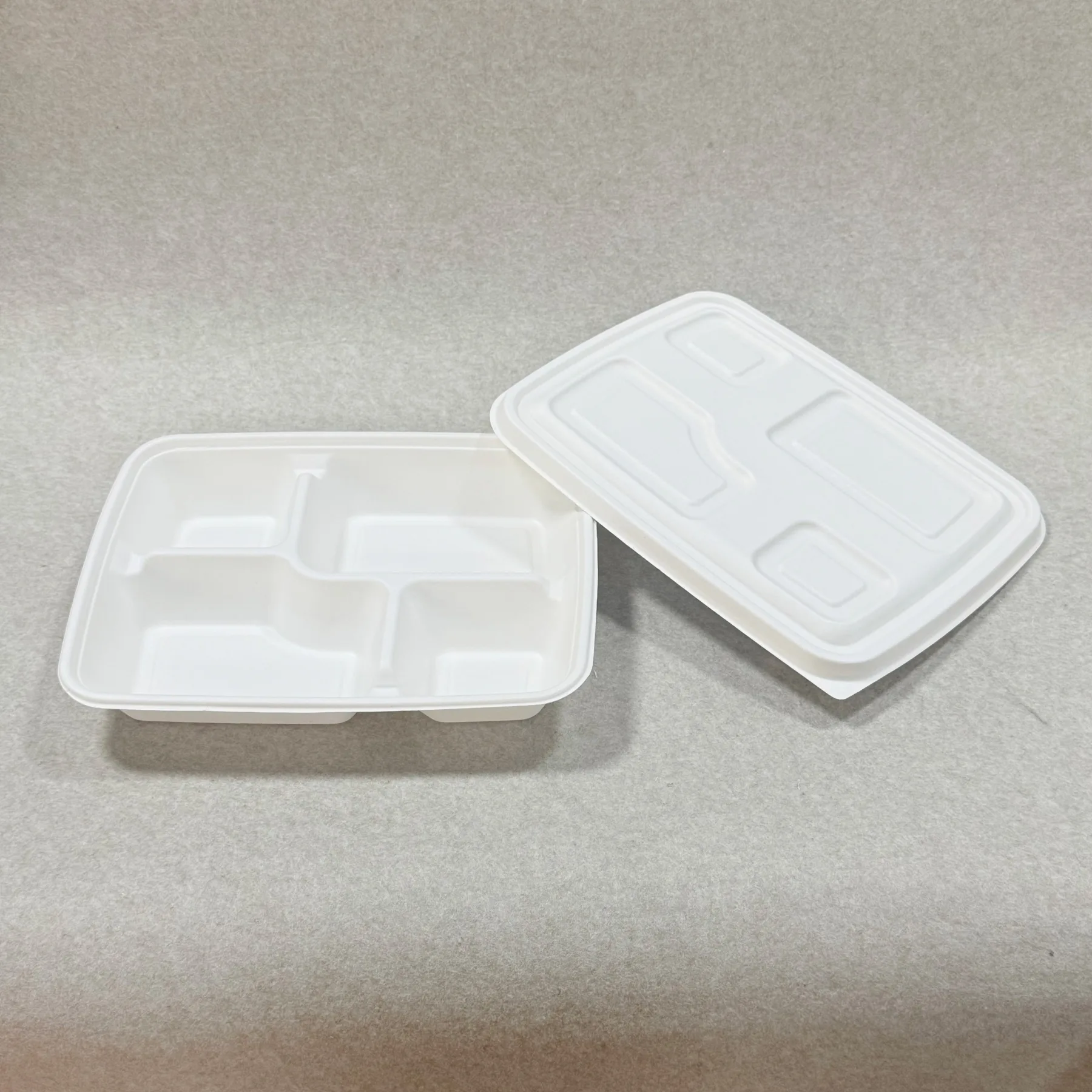 صورة معروضة لحاوية الغداء القابلة للتحويل إلى سماد حيوي ذات 4 حجرات مع غطاء من تفل قصب السكر، مما يسلط الضوء على خيار التغليف القائم على الألياف لتغليف الوجبات المستدامة وبرامج الحد من البلاستيك.