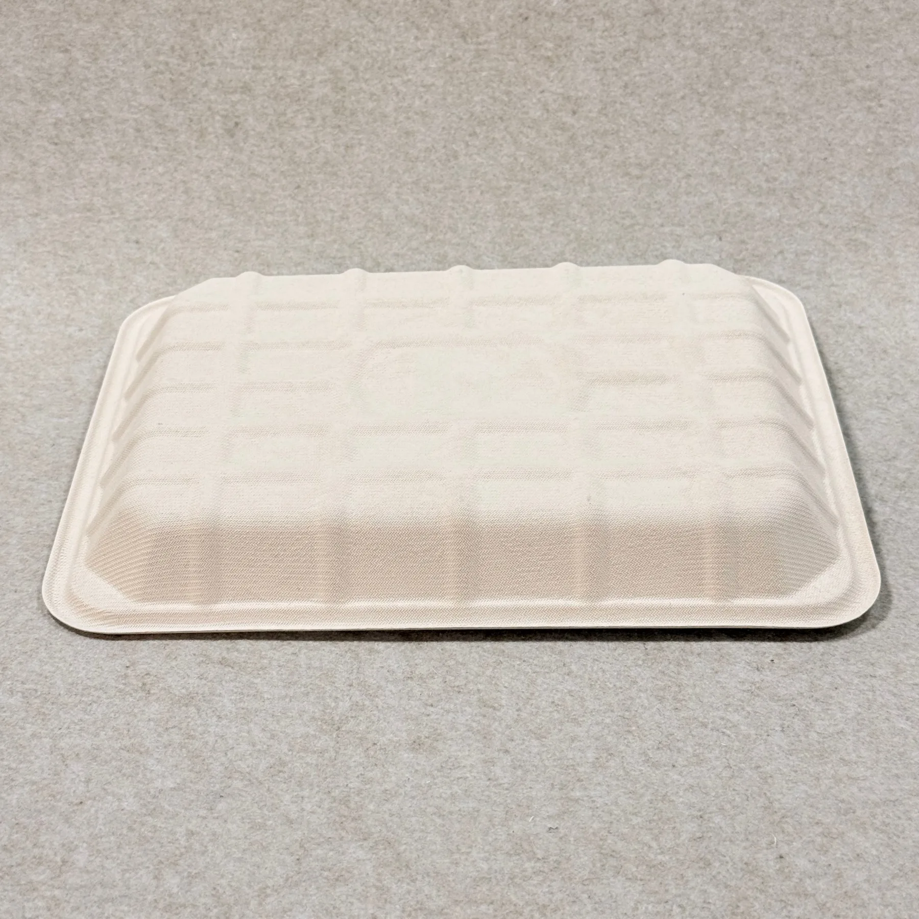 Dettaglio del vassoio per carne in bagassa compostabile che mostra la struttura della polpa stampata e la finitura dei bordi