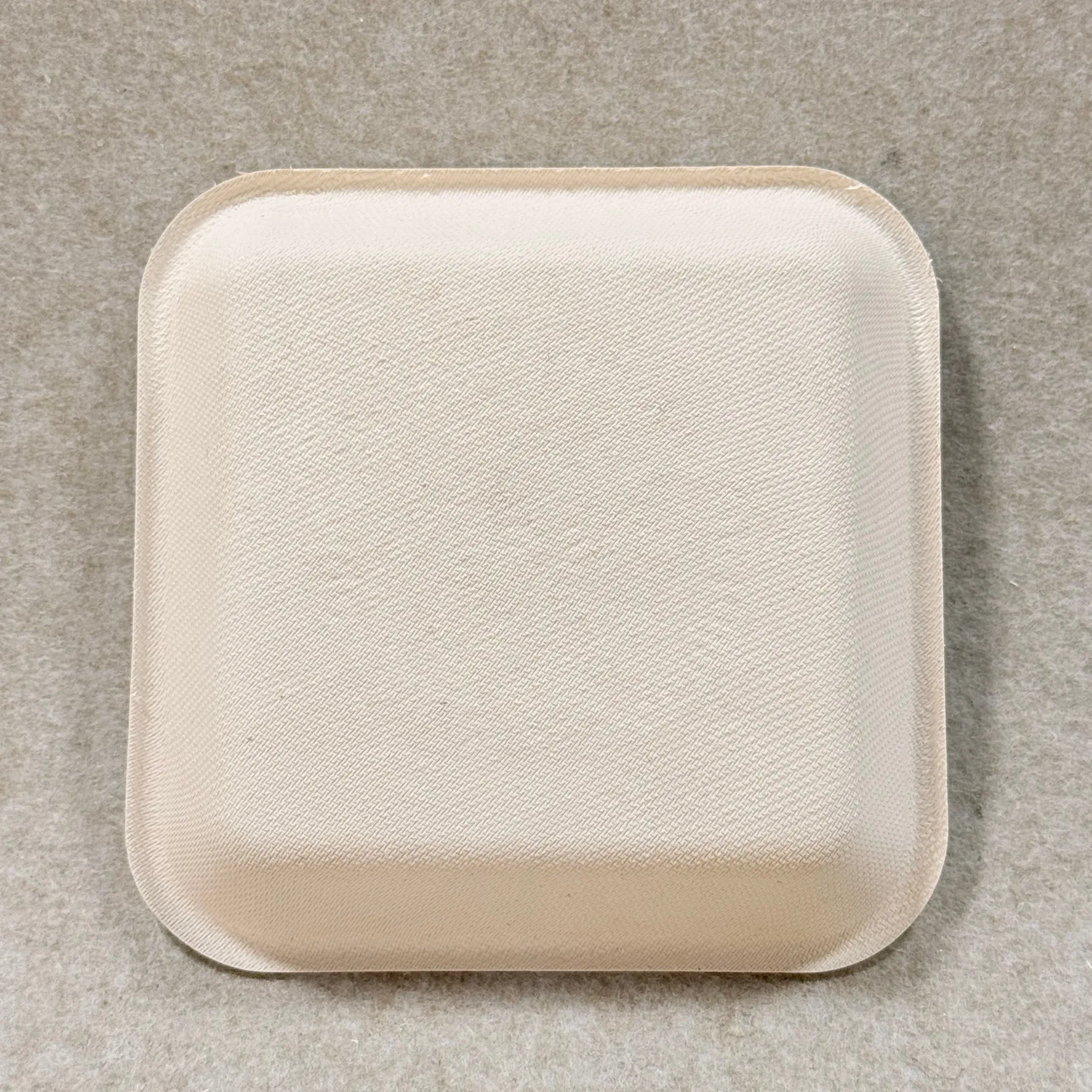 Detalle de la bandeja de aperitivos compostable que muestra la textura del bagazo moldeado y el acabado de los bordes