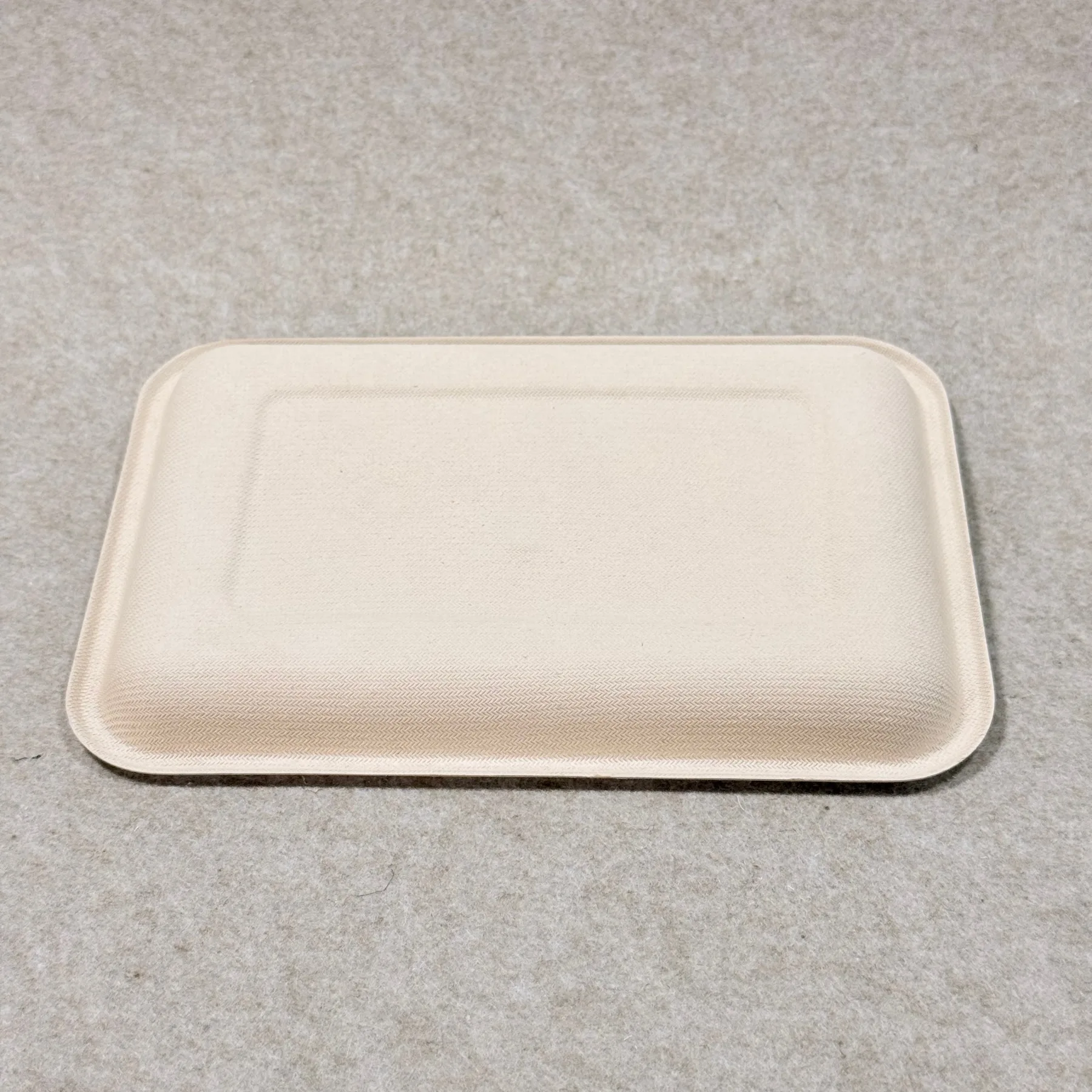 Dettaglio del vassoio espositivo per supermercati compostabile che mostra la struttura della pasta stampata e la finitura dei bordi